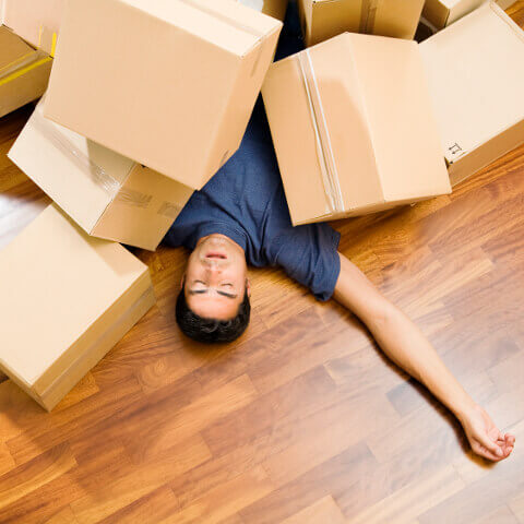 The man sleeping under moving packing boxes in home at Hurst, TX